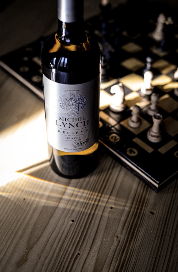 photographie d'une bouteille de graves devant un jeu d'échec